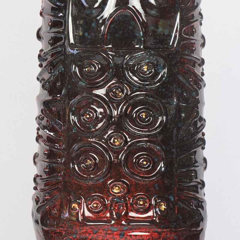 Detail of a figurative expressionist totemic glazed ceramic sculpture by Giorgio Crisafi. Mainly red colors. Title: Golden Apparition II