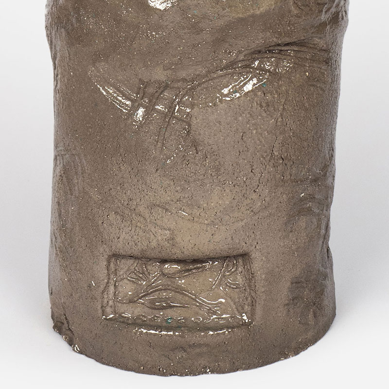 Detail of a figurative expressionist totemic glazed ceramic sculpture by Giorgio Crisafi. Mainly brown colors. Title: Earth Apparition