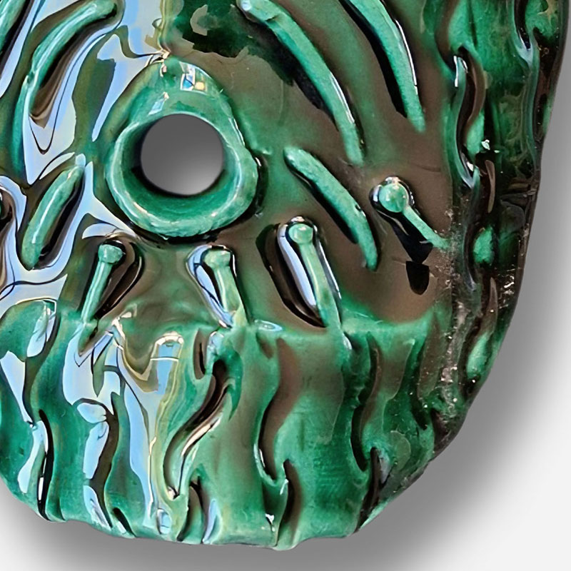 Detail of a figurative expressionist relief depicting Green God Mask by Angelo Canevari. Mainly green colors. Title: Green God Mask