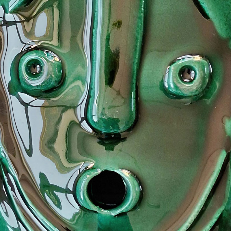 Detail of a figurative expressionist relief depicting Green Goddess Mask by Giorgio Crisafi. Mainly green colors. Title: Green Goddess Mask II