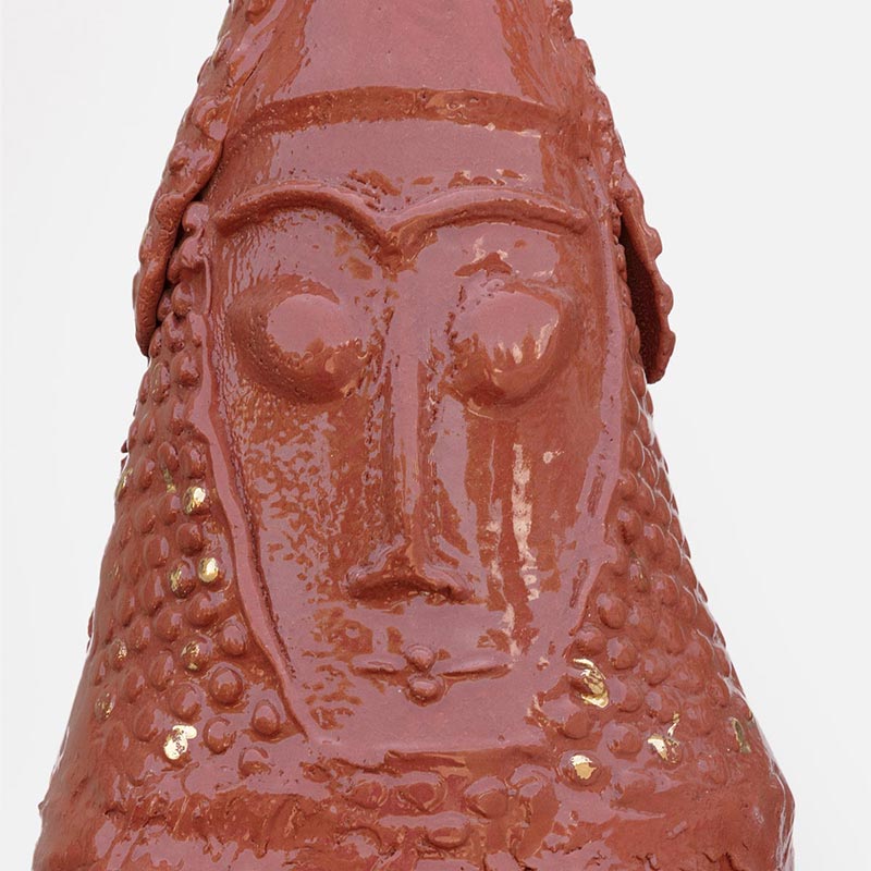 Detail of a figurative ceramic sculpture by Giorgio Crisafi, pink-orange terracotta glaze with gold on nodular scaled crown, Personaggi series. Title: Abitante in Terra II